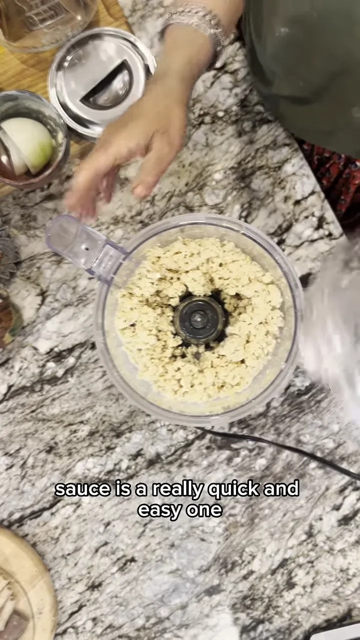 Crumbly pale-yellow tofu mixture around the blade of an open food processor