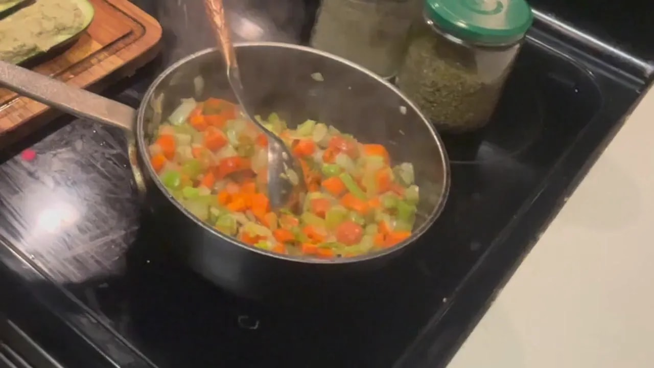 Softened diced carrots, celery, and onion in a saucepan on the stove